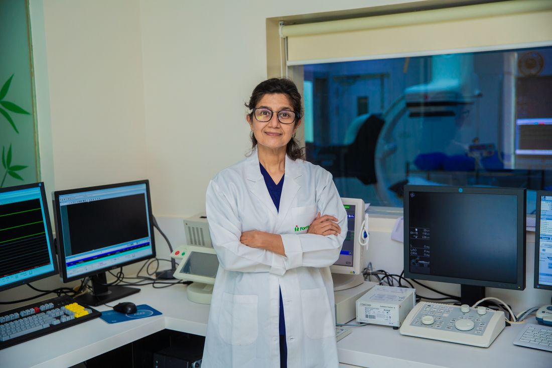 A radiologist standing in front of imaging workstations